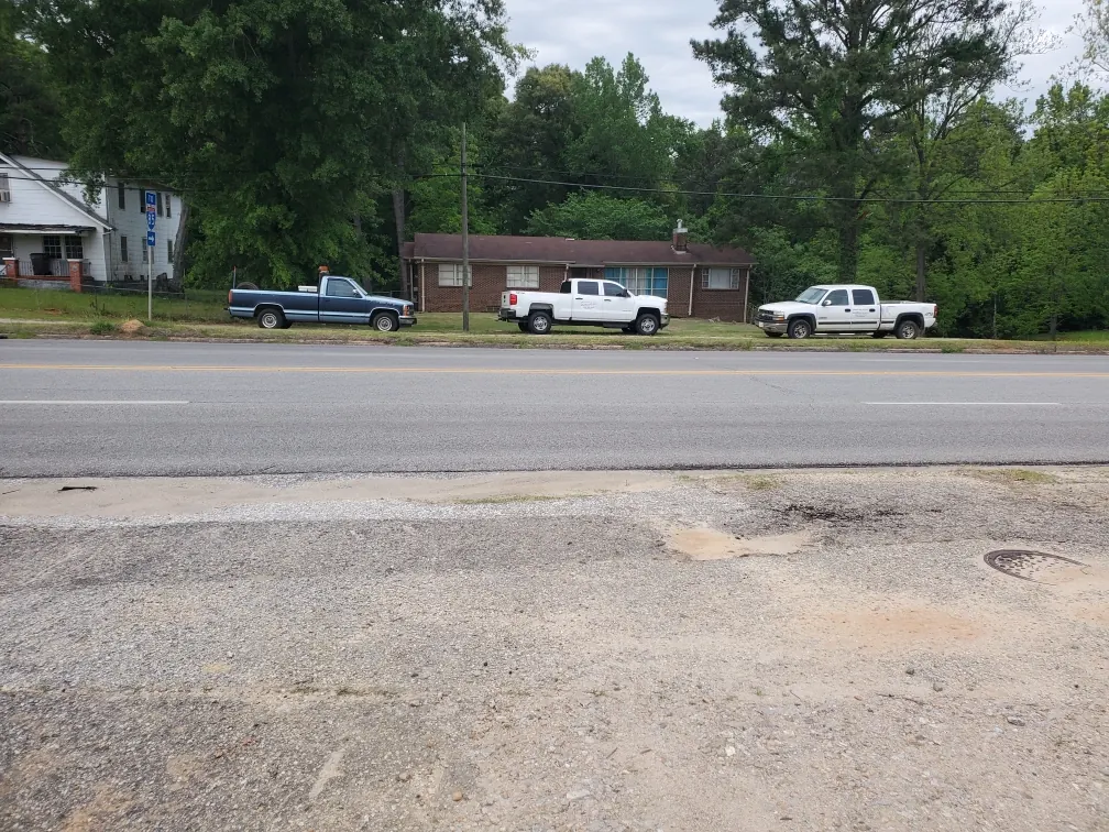 Roadside view of a residence and several parked work vehicles