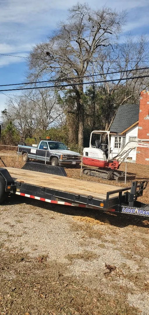 Work equipment on a trailer near a leafless tree